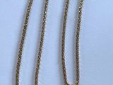un collier orné d'une pièce de monnaie, posé sur une surface blanche