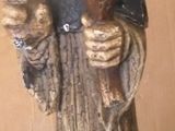 a statue of a man with a hat on holding a cell phone