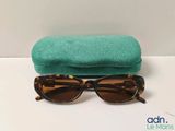 a close up of a pair of sunglasses with a green case