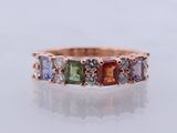 un gros plan sur une bague en or rose sertie de pierres multicolores