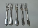 four forks and a knife are lined up on a table