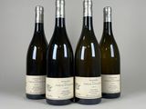 quatre bouteilles de vin sont alignées sur une table