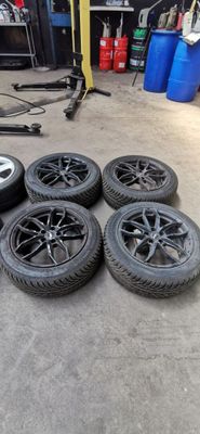 quatre pneus sont posés par terre dans un garage