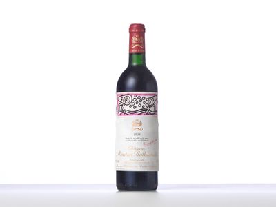 a bottle of red wine sitting on top of a white table