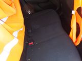 a man in an orange vest sitting in the back seat of a car