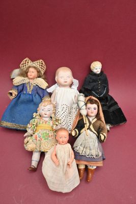 five dolls that are sitting together on a red surface