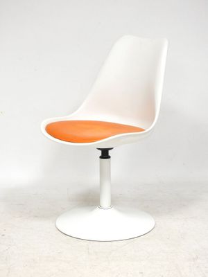une image représentant une chaise blanche avec une assise orange posée sur une surface blanche