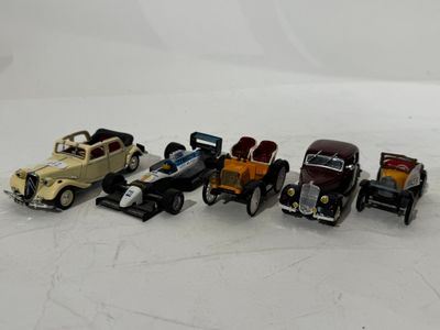 several toy cars are lined up in a row on a white surface
