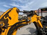 a yellow backhoe of a construction vehicle parked in a lot