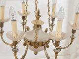 a chandelier made of glass and brass with five lights