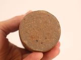 a person holding a small round object in their hand
