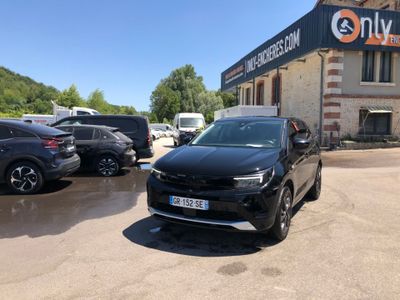 a black suv parked in front of a building with cars parked in front of it