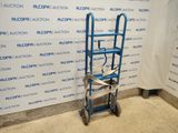 a blue hand truck with a blue ladder in front of a wall