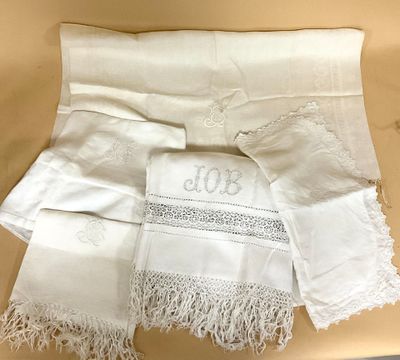 plusieurs pièces de linge blanc ornées de dentelle, posées sur une table