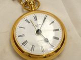 a gold pocket watch with roman numerals on it