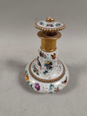 a white and gold vase with a bird on it