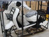 un scooter posé sur un chariot dans un entrepôt