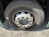 a green truck with a flat tire on the road