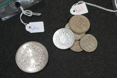 a pile of silver coins and a silver coin with a price tag