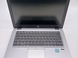 a silver laptop computer sitting on a white surface