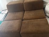 a brown couch and ottoman sitting on a white table