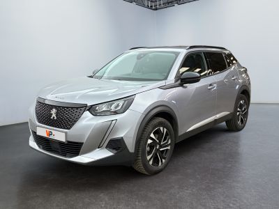 Le SUV argenté est garé dans une pièce au sol noir.