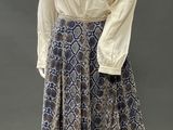 a mannequin wearing a skirt and blouse with a ruffled collar