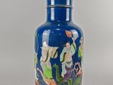 un vase bleu orné d'une image représentant des personnes