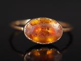 une bague en or avec une pierre orange au centre