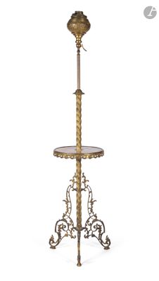 un lampadaire ancien en laiton, doté d'un abat-jour en verre et monté sur un pied