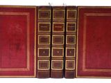 un vieux livre ouvert, dévoilant une couverture rouge aux bordures dorées