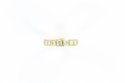 une bague en or jaune sertie de trois diamants sur fond blanc