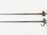 pair of old swords on a white surface with a white background