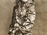 an old photo of a woman with curly hair wearing a coat