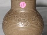 un vase marron sur lequel est collé un autocollant rose