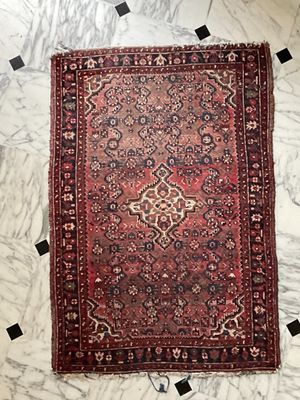 an old persian rug on a marble floor with black and white squares