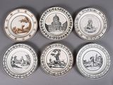 six assiettes ornées de motifs différents, posées sur une surface grise