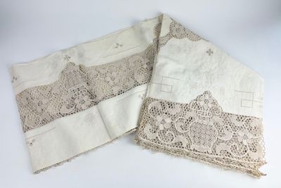 deux morceaux de dentelle sont posés sur une surface blanche
