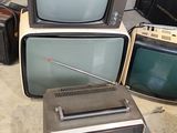 several old televisions are stacked on top of each other in a room