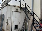 un tas d'ordures devant un immeuble, près d'un escalier