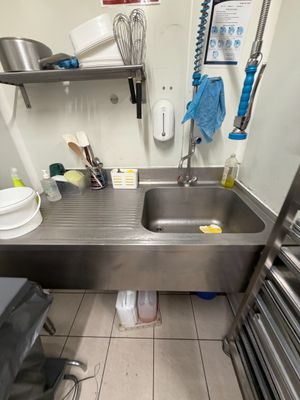 a kitchen with a sink and a metal counter