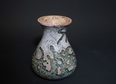 a small vase with a green and white design on it