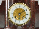 a clock that has a statue of a man on top of it