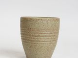 green and white ceramic cup on white background