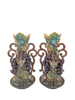 two vases with grapes on them on a white background