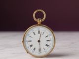 une montre de poche en or avec des chiffres romains sur le cadran