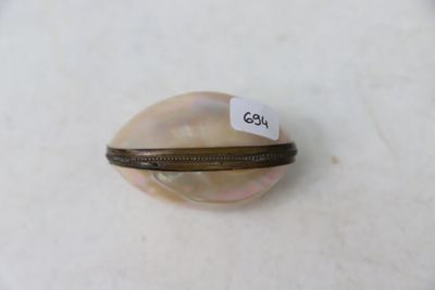 une image représentant un petit coquillage sur lequel est accrochée une étiquette