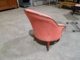 une chaise rose qui se trouve dans une pièce