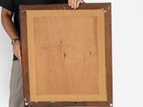 painting of a man holding a wooden frame in front of a white wall
