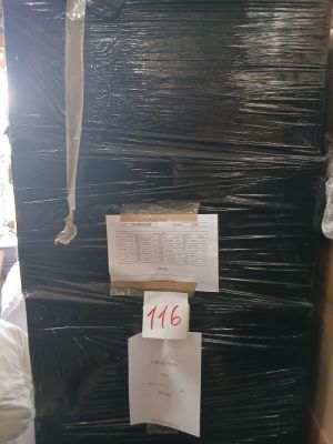 un grand réfrigérateur noir au milieu d'une pile de cartons